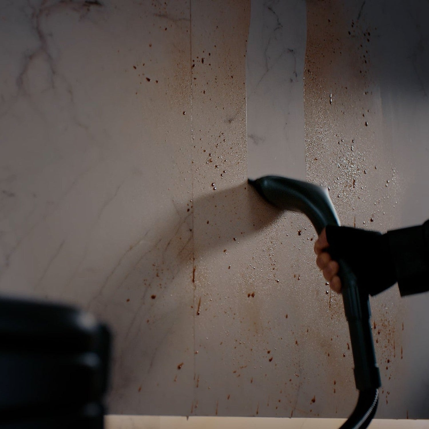 PUDU SH1 handheld accessory cleaning a splattered vertical wall