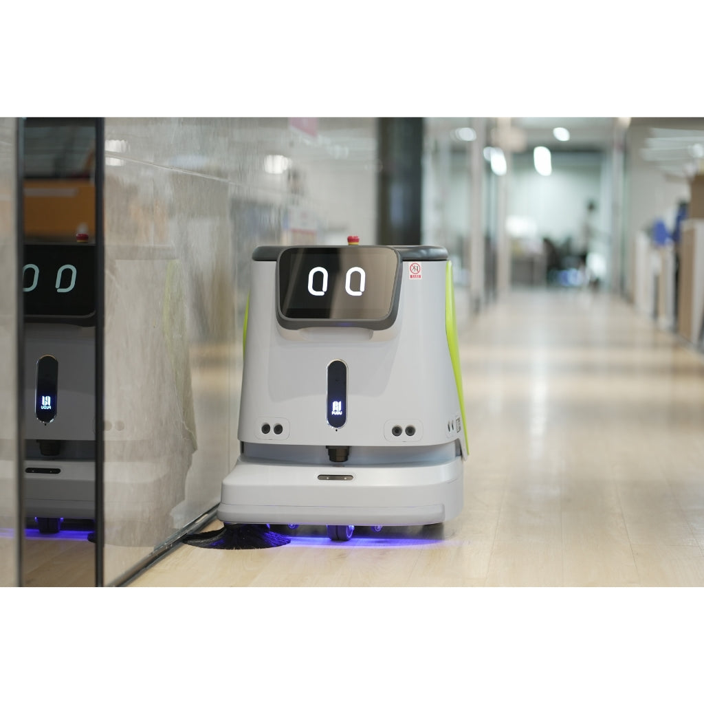 PUDU CC1 robot cleaning a modern office corridor with glass walls and hard flooring.
