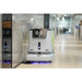 PUDU CC1 robot cleaning a modern office corridor with glass walls and hard flooring.