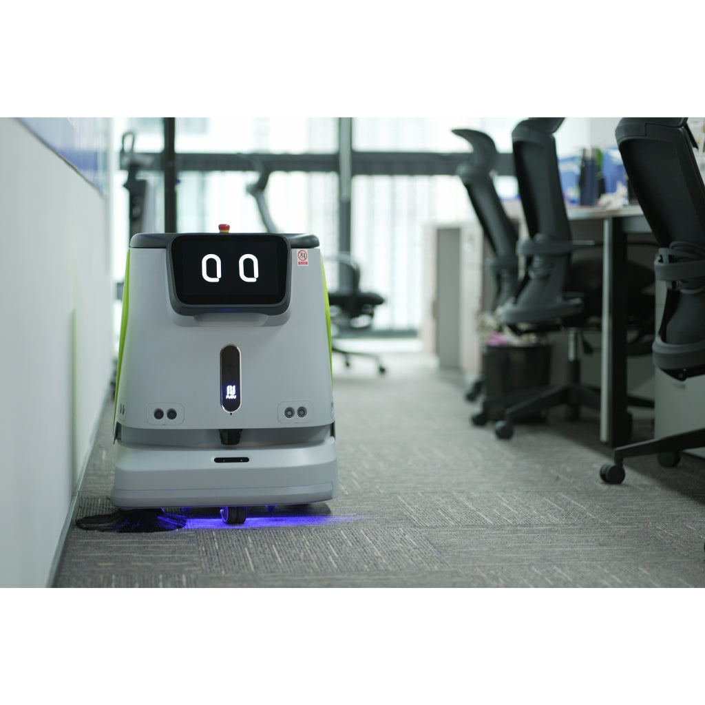 PUDU CC1 intelligent cleaning robot vacuuming office flooring near meeting room chairs.