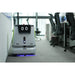 PUDU CC1 intelligent cleaning robot vacuuming office flooring near meeting room chairs.