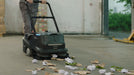 PUDU MT1 AI powered robotic sweeper in its manual mode, sweeping waste