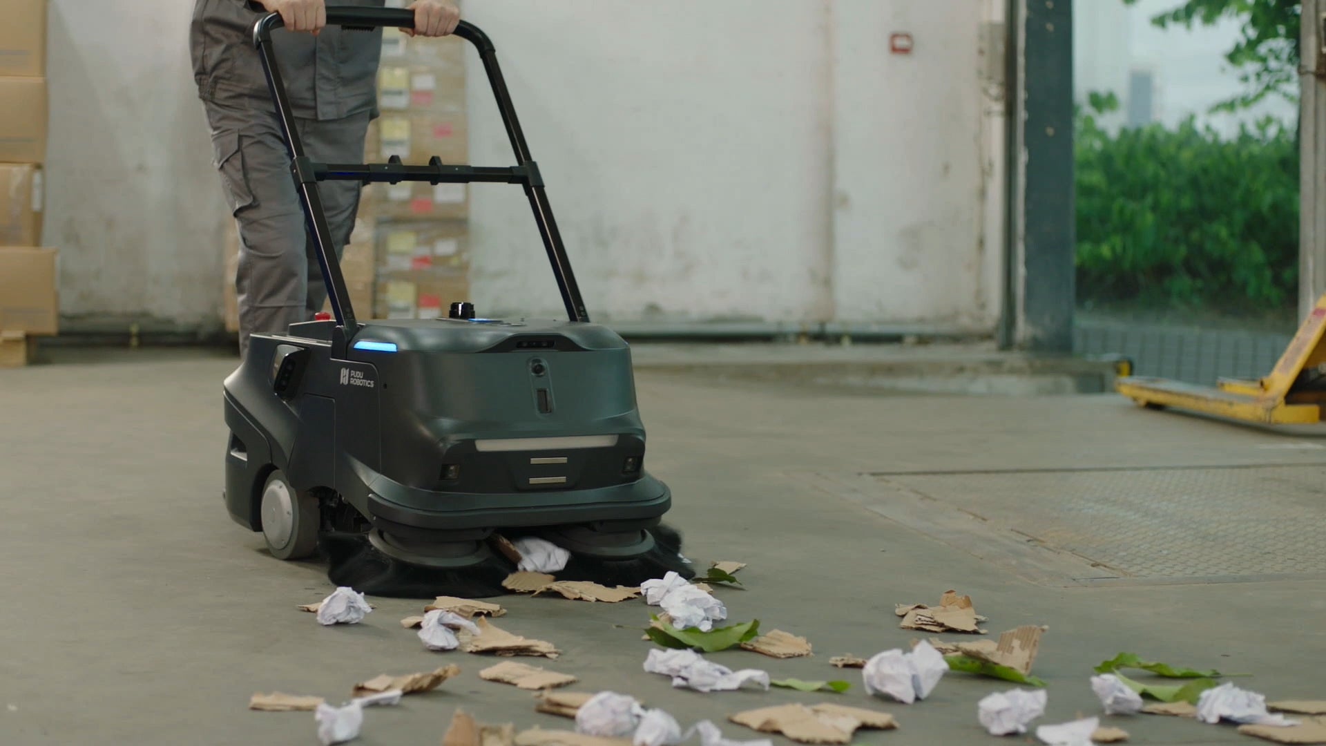PUDU MT1 AI powered robotic sweeper in its manual mode, sweeping waste