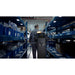 PUDU T300 navigating a narrow warehouse aisle between blue shelving units, demonstrating compact design.